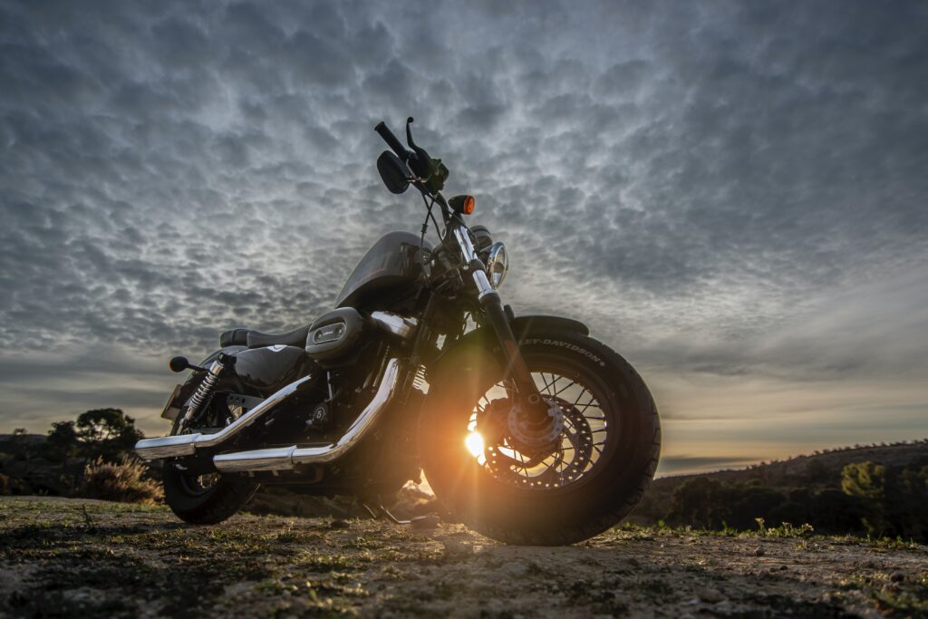 Picture of motorcycle at sunset, overcast, sun behind